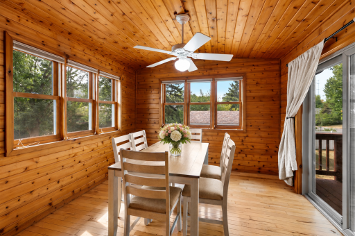 Warm, sun-filled four-season porch with beautiful woodwork and plenty of space to relax or dine!