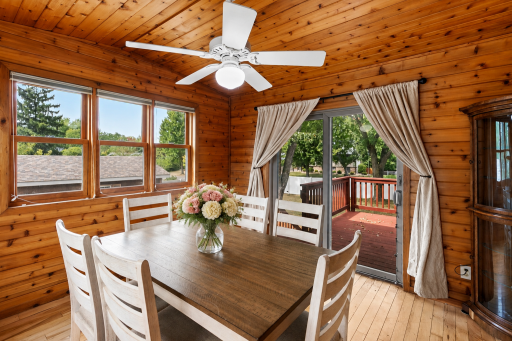 Warm, sun-filled four-season porch with beautiful woodwork and walkout to a large deck, perfect for entertaining!