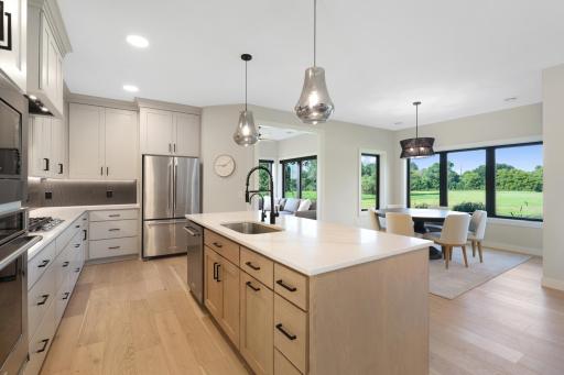 Custom cabinetry, tile backsplash, and beautiful backyard views make meal preperation a pleasure.