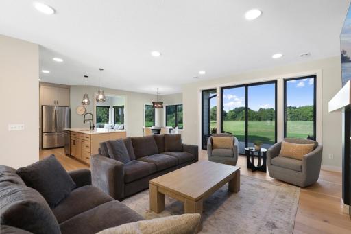 Expansive windows showcase serene views of the backyard and picturesque tree line.