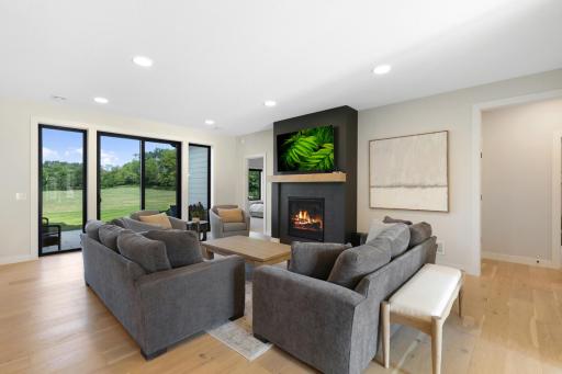 Great room features a patio door flanked by floor-to-ceiling windows, beautifully framing the backyard views.