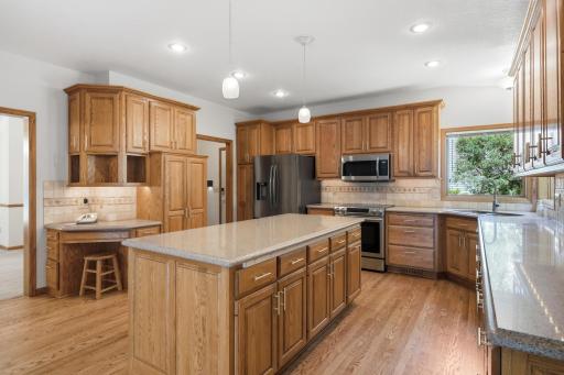 Handy planning desk, Large pantry cabinet, and pendant lights over center island