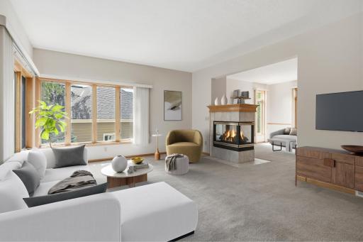 (virtual staged) Very large main floor family room just off the kitchen/informal dining area. Unique 3 sided fireplace dividing family room from formal front living room