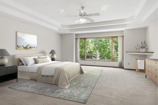 (virtual staged) Very large primary bedroom with boxed out huge picture window overlooking trees in back. Double race track ceiling with ceiling fan