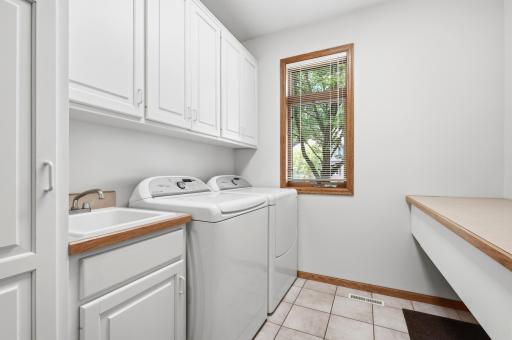 Just off the kitchen is a nice size laundry room with window to the front of the home, large folding counter with under drawer storage and nice cabinets built in