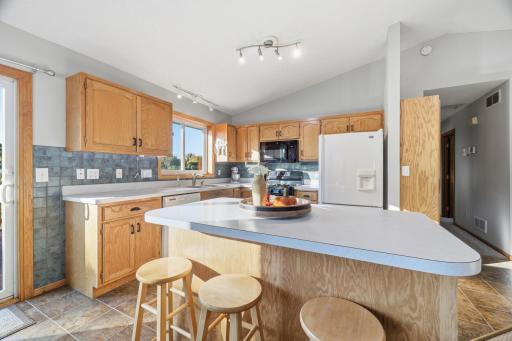 Kitchen with kitchen island, vaulted ceiling, kitchen window