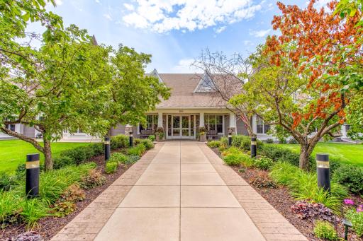 Beautifully landscaped community entrance with a welcoming covered entry and attractive stone accents.