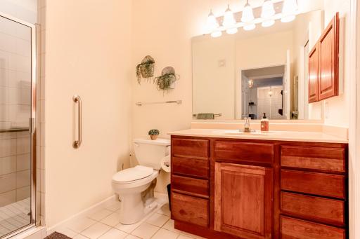Private 3/4 primary bath features tile flooring, generous vanity storage, and a large walk-in shower.