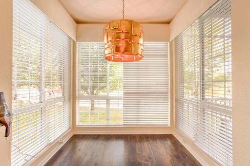 Bright informal dining nook surrounded by windows, offering panoramic views and an abundance of natural light.