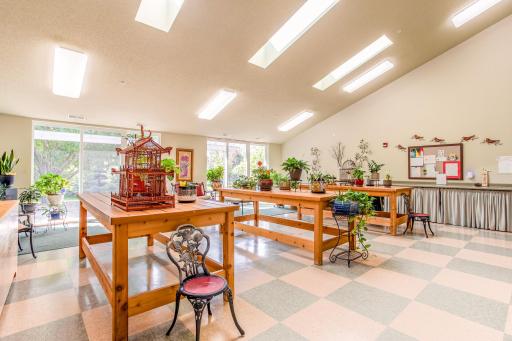 Sunlight pours into this charming garden solarium, creating a bright, peaceful spot to sit, visit, and enjoy the greenery year-round.