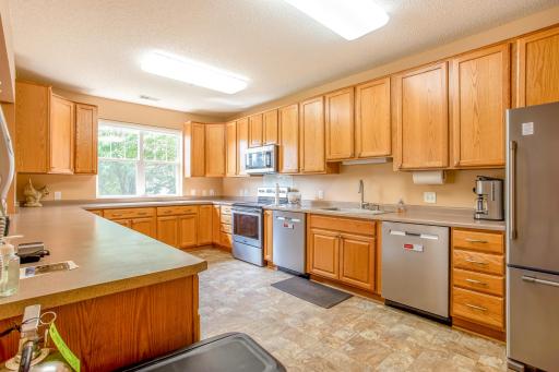 The adjoining full kitchen offers extensive cabinetry, generous counter space, and appliances for convenient event prep and entertaining.