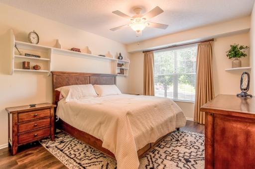 Spacious primary bedroom features LVP flooring, a ceiling fan, and a large window filling the room with natural light.