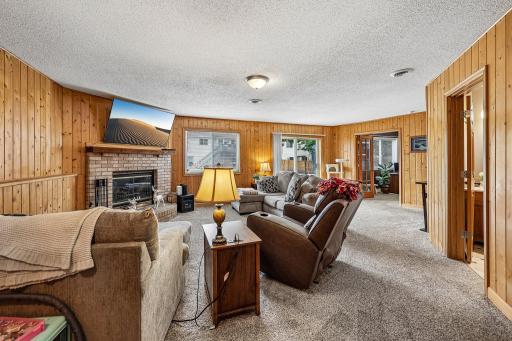 Cozy lower-level family room centered around a warm wood-burning fireplace.