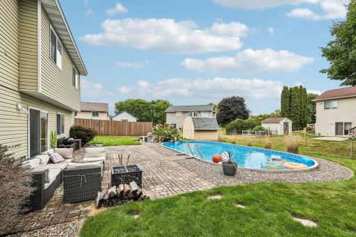 Exceptional outdoor setting with an in-ground pool, large patio, and lush backyard.