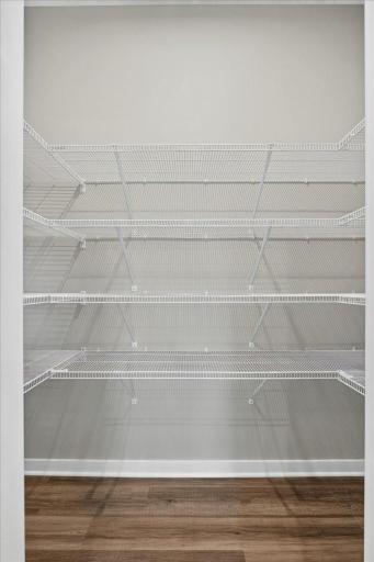 PHOTO OF A DIFFERENT HOME WITH SIMILAR PLAN AND FINISHES. Kitchen Walk-in Pantry offers shelving on three walls for added storage.