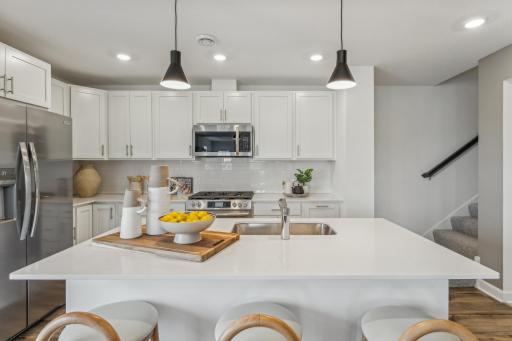 (Photo of a model home, actual homes finishes will vary) This kitchen is very open and connect seamlessly to the dinning area!