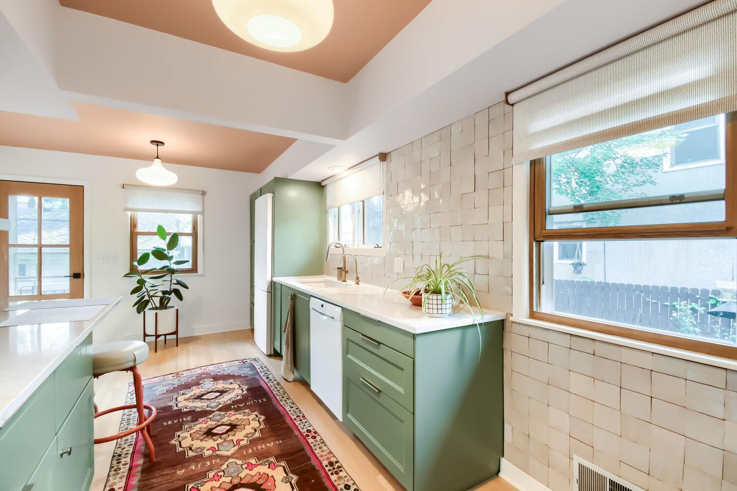 Kitchen with custom tiled wall and custom blinds.