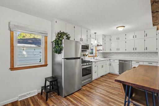 Updated kitchen with stainless steel appliances, tiled backsplash, and generous cabinet storage.