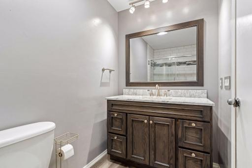 Beautifully updated full bathroom on the main level features a granite-topped wood vanity, large framed mirror and fresh paint!