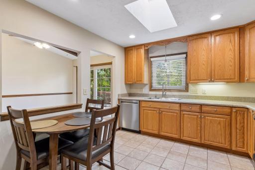 Bright kitchen features a cozy eating area, natural light from a skylight, and a seamless connection to the living spaces!