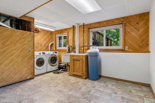 Spacious laundry and utility room featuring a front-load washer and dryer, active radon mitigation system, and a sump pump with a battery backup.