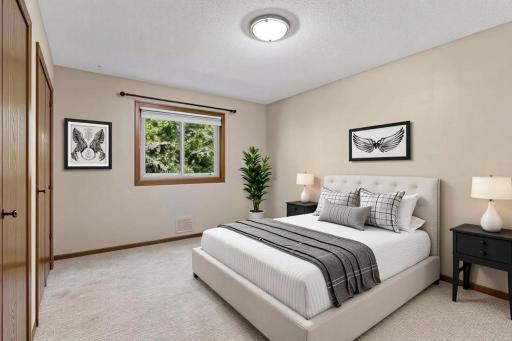 Bright primary bedroom featuring freshly painted walls, plush carpeting, a large window with peaceful views, and a convenient double closet! *Virtually staged to show design options.