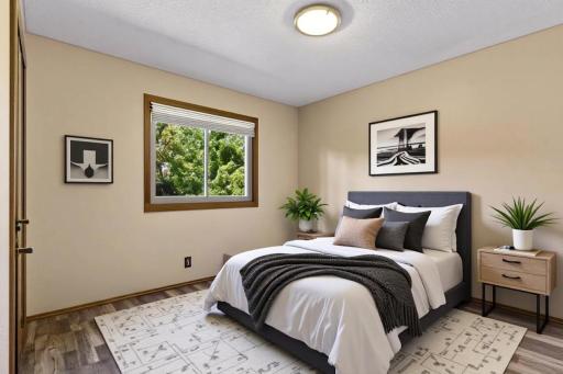 Main level bedroom two, which is one of three on this floor features beautiful updated flooring, neutral paint, and excellent natural light! *Virtually staged to show design options.