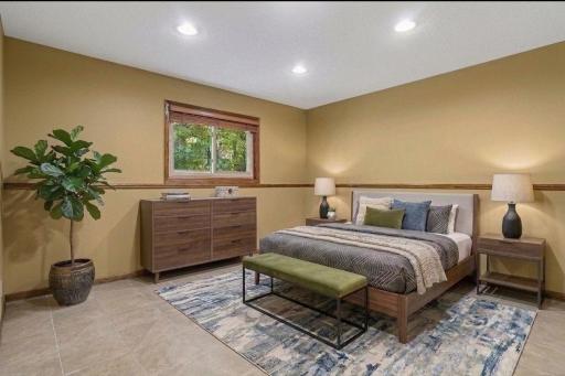 Spacious lower level bedroom four features warm neutral tones, tile flooring, and stylish recessed lighting. *Virtually staged to show design options.