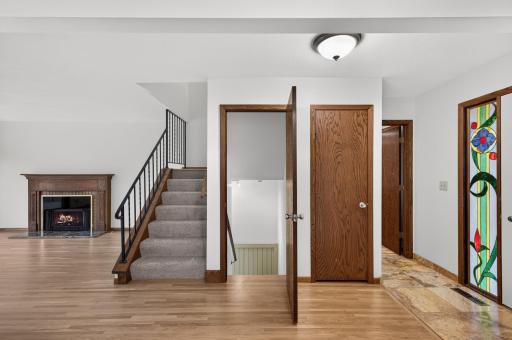 New carpet on the stairs, door to lower level between stairway to upper level and coat closet