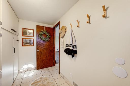 Walk in through the entryway, featuring tile floors and storage cabinets.