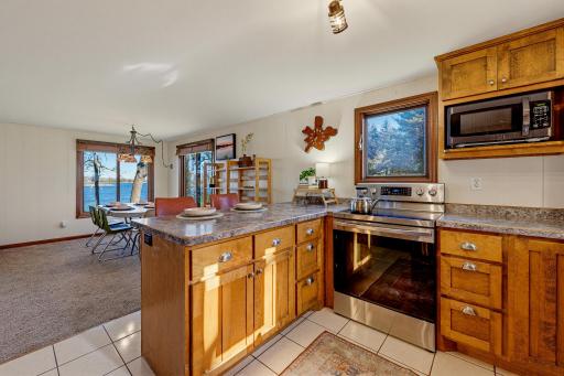 Newer custom wood cabinets and a tile floor are featured in the kitchen.