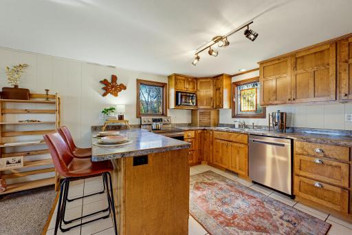 The updated kitchen features a full suite of S.S. appliances including dishwasher, range, refrigerator, and microwave.