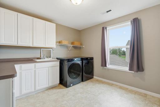 Oversized upper level laundry room with sink and custom cabinetry!