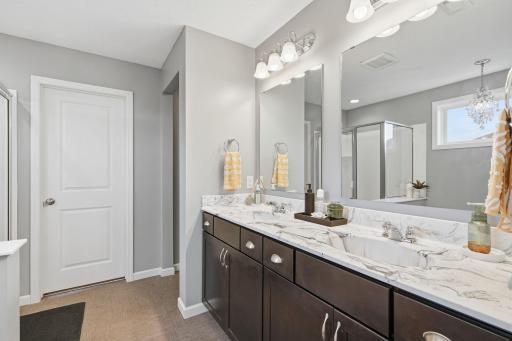 Large primary bath with elevated counter height, dual sinks, quartz counters and tile floors!