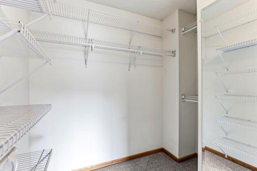 Wire shelving on three walls turns the walk-in closet into a well-organized wardrobe, with room for hanging clothes, shoes, and seasonal storage.