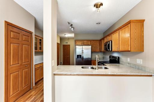 Granite counters wrap the peninsula in this kitchen, with a raised breakfast bar for quick meals and warm oak cabinetry above and below.