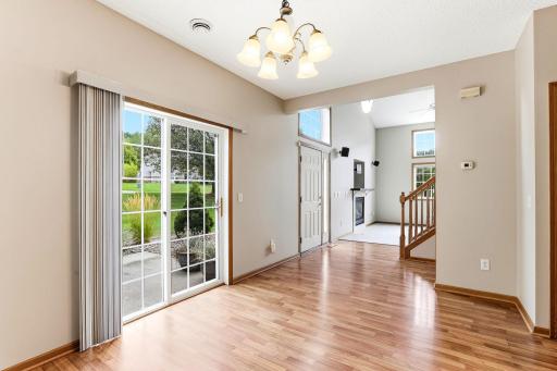 Sliding glass doors bring the backyard into the dining room, and the sightline runs straight to the fireplace and staircase in the great room.