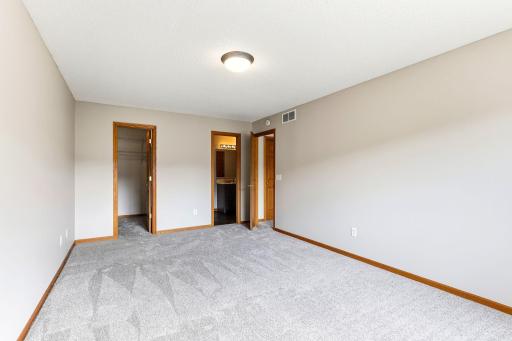 Wake up in the primary suite, where a walk-in closet and private ensuite bath sit just off a generous carpeted bedroom.