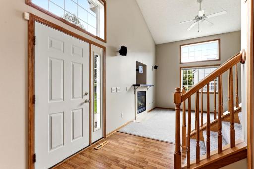Step inside to a vaulted entry that opens straight into the great room, where a gas fireplace and oak staircase set a welcoming tone from the first hello.