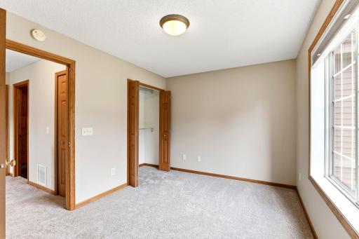 Double closet doors and a big window keep this bedroom bright and practical, with the hall bath just steps away.
