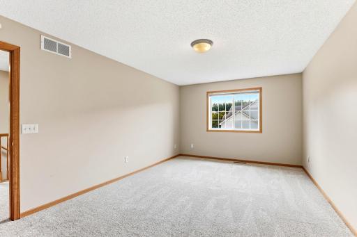 Neutral walls and soft carpet make this spacious bedroom a flexible fit for kids, guests, or a home gym.