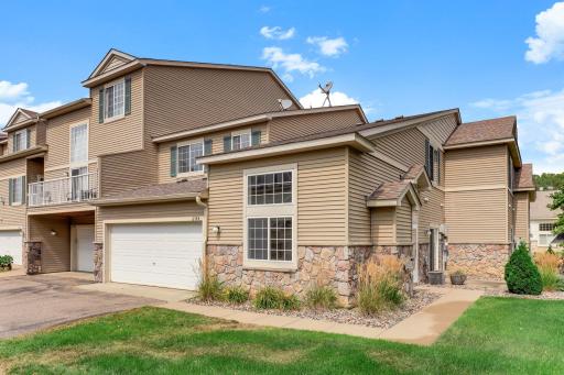 Stone accents, warm siding, and a two-car garage give this end-unit townhome real curb appeal, with the extra windows and green space that only a corner spot can offer.