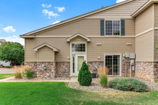 A private gabled entry with stone wainscoting feels more like a single-family home than a townhome. Ornamental
grasses and evergreens finish the look.