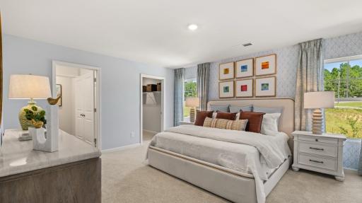 Relax and recharge in your primary suite, a peaceful space featuring an en-suite bath and walk-in closet. Photo of model home, colors and finishes may vary.