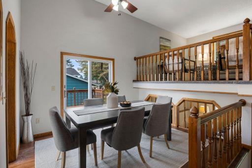 The kitchen opens directly to the dining room, which showcases vaulted ceilings, a modern hanging light fixture, and direct access to the 15x12 deck.