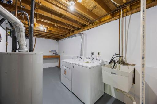 The large, clean laundry and utility room features a new washer and dryer (2025) along with plenty of additional storage space.