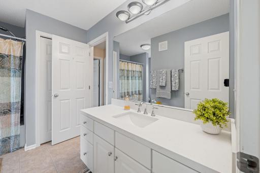 Upper level full bath with oversized vanity & linen storage.