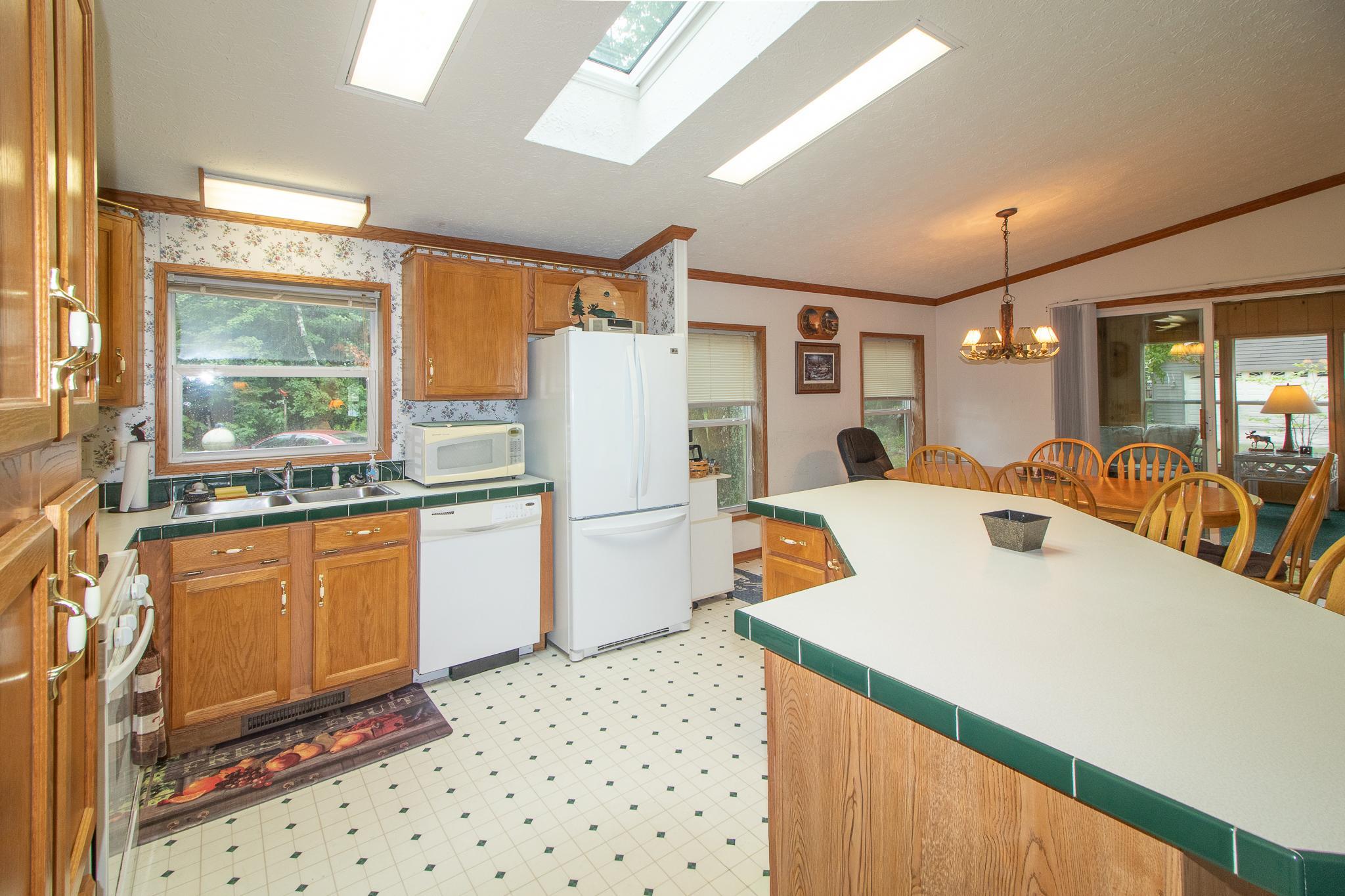 Kitchen and coffee bar on the other side of the refrigerator in dining area.
