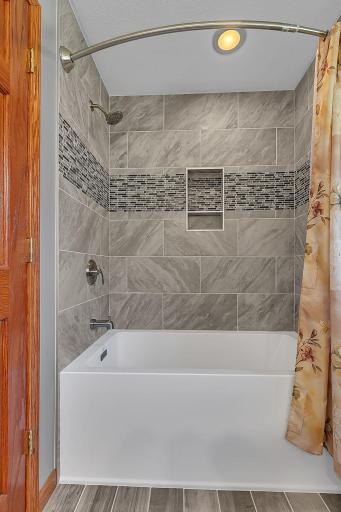 The private primary suite offers a newly installed deep soaking tub, tile shower, tile floor, new vanity, and fresh paint.