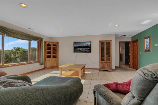 Lowe level family room with tile floors, in-floor heat, large windows, can lighting, wet bar area, and walk out to your concrete patio.